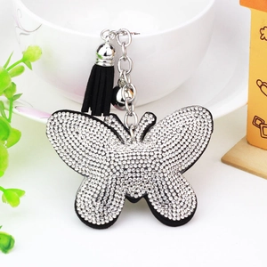 Detail shot of a sparkling butterfly keychain with rhinestones, black tassels, and silver bell