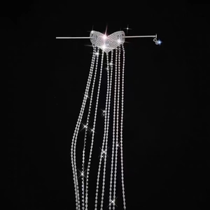 Macro detail of silver heart hair stick with long sparkling rhinestone tassels on black