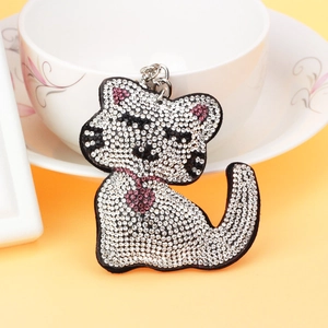 Porte-clés chat scintillant avec strass blancs et roses sur fond jaune clair