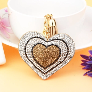 Macro shot of tiered heart pendant with sparkling rhinestones and a brown silk tassel charm