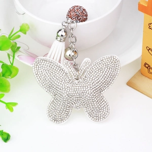 Detail of rhinestone butterfly keychain with leather tassel and silver bell accessory