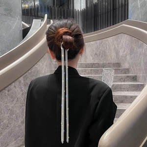 Detailed view of silver heart hair pin with long sparkling rhinestone tassels on model