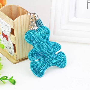 Sky blue rhinestone bear keychain with tassel charm and silver ring on white table
