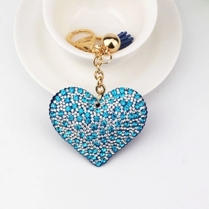 Detail of blue rhinestone heart keychain with golden clip and dark blue tassel accent