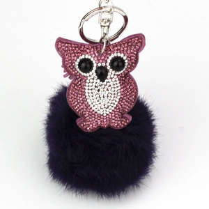 Fashionable owl keychain featuring pink rhinestones and a dark purple fluffy fur pom pom