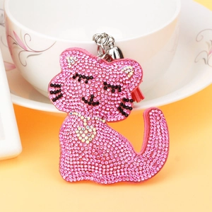 Vue détaillée du porte-clés chat en strass rose avec cœur argenté et pompon rouge