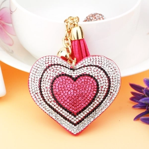 Detail of pink heart-shaped keychain with rhinestones, gold chain and stylish tassel