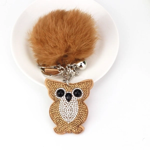 Detail of owl keychain with champagne rhinestones, brown pom-pom and metallic bell