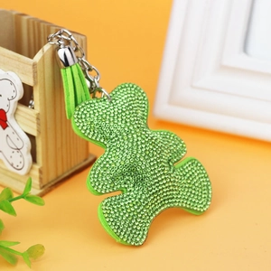 Detailed close-up of light green bear keychain with sparkling rhinestones and suede tassel