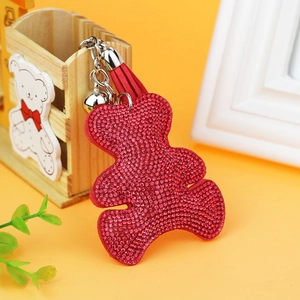 Detail of red bear keychain with sparkling rhinestones, leather tassel, and silver bell