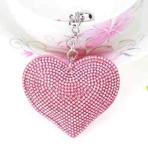 Close-up of pink crystal heart pendant with silver chain and rhinestones for bags