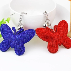 Sparkling butterfly keychain with rhinestones and bells in blue and red velvet