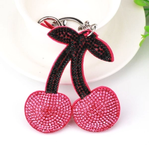Close-up of pink rhinestone cherry keychain with velvet texture and silver ring