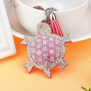 Detailansicht eines rosa Schildkröten-Schlüsselanhängers mit Kristallen und Lederquaste