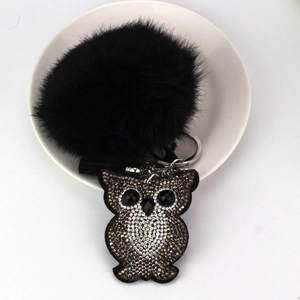 Fashionable owl keychain with a large black fluffy fur pom pom and rhinestone details