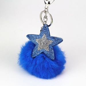 Détail d'un porte-clés étoile en strass bleus avec pompon en peluche et métal argenté