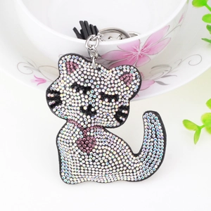 Détail du porte-clés chat avec strass brillants et décoration de pompon noir élégante