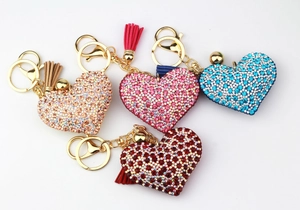 Macro shot of colorful rhinestone heart keychains with matching silk tassels and gold clips