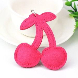 Detailed view of fuchsia cherry felt charm with precise stitching and silver metal ring