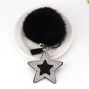 Détail du porte-clés pompon noir avec étoile en strass et pompon en cuir élégant