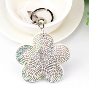 Dettaglio portachiavi a forma di fiore con strass di cristallo e nappa in pelle scamosciata