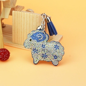 Dettaglio portachiavi a forma di pecora con strass blu, campanellino e nappa in pelle