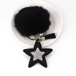 Détail du porte-clés à pompon noir avec étoile en strass et pompon en cuir élégant