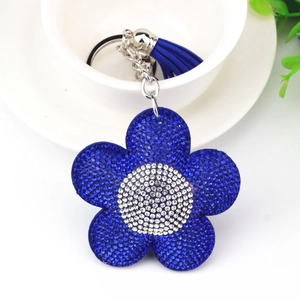 Portachiavi girasole con strass blu e nappa di seta appeso a una tazza di porcellana
