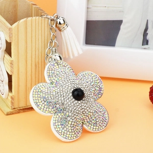 Détail du porte-clés tournesol avec strass scintillants et un gland blanc élégant