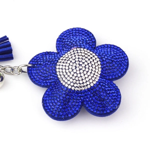 Dettaglio portachiavi a fiore con strass blu e bianchi e nappina in camoscio blu