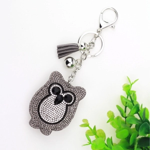 Sparkly owl keychain with grey tassels and silver bell on a clean white background