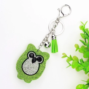 Detailed view of green rhinestone owl keychain with silver bell and matching silk tassel