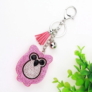 Sparkling pink rhinestone owl keychain with silver tassel and bell on white background