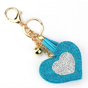 Portachiavi a cuore scintillante con nappe azzurre e strass su uno sfondo bianco