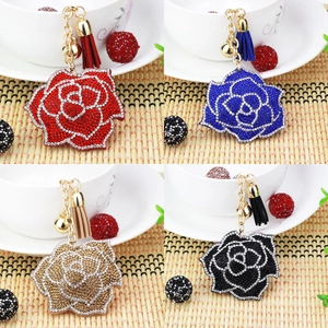 Detail view of rose crystal keychains in red, blue, champagne, and black with tassels