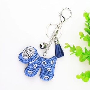 Blue rhinestone dog keychain with silver bell and matching tassel on white background