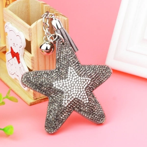 Close-up of sparkling star-shaped keychain with crystal rhinestones and grey tassel