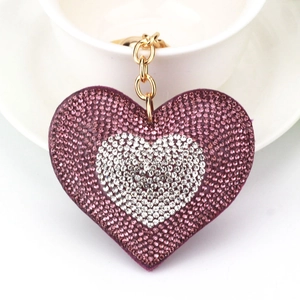 Dettaglio macro del portachiavi a cuore con cristalli viola e bianchi e anello