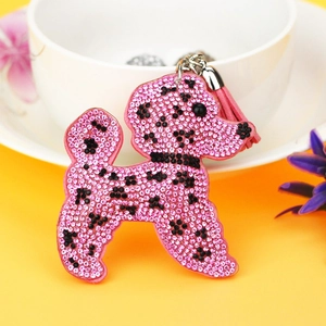 Porte-clés caniche en strass rose et pompon en cuir sur un fond jaune vif éclatant