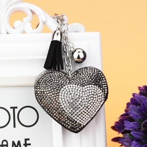 Dettaglio del ciondolo a cuore bicolore con strass, nappa in camoscio nero e catena in argento
