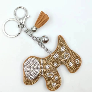Détail macro du porte-clés chien Scottie avec strass blancs et dorés et pompon marron
