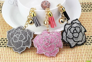 Detailed view of luxury camellia keychains with rhinestones and tassels in three colors