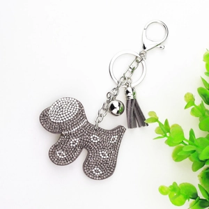 Detail of velvet dog keychain featuring silver rhinestones, a bell and a grey tassel