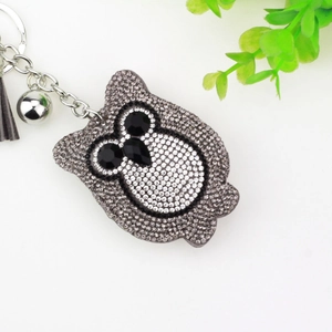 Fashionable owl keychain with rhinestones and tassel hanging on a clean white background