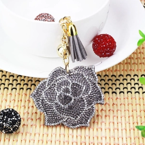 Close-up of sparkling rose keychain with grey crystals and elegant suede tassel detail