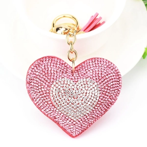 Dettaglio portachiavi a cuore con strass rosa, catena dorata e nappa in pelle scamosciata