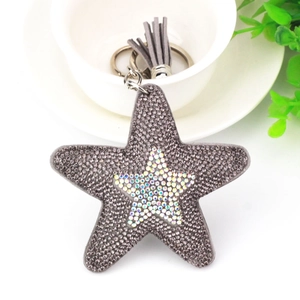 Detail of grey star keychain with crystal rhinestones and leather tassel accessory