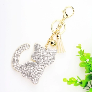 Détail d'un porte-clés en forme de chat avec strass argentés et un pompon blanc