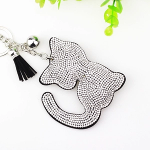 Vue macro détaillée du porte-clés chat en strass avec pompon noir et clochette