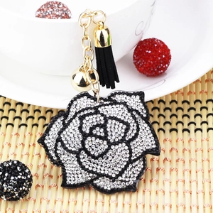 Close-up of rose flower keychain with black and white rhinestones and a gold bell
